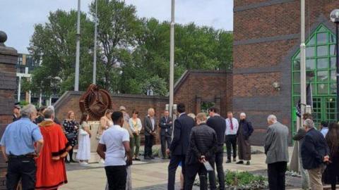 Visitors and dignitaries stand around the Srebrenica Memorial in Hull as part of a service in 2023