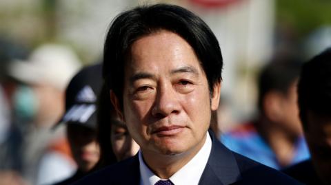 William Lai wears a dark coloured suit and white collared shirt