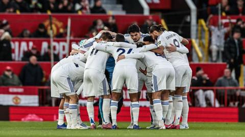 Leeds United players huddle before kick-off