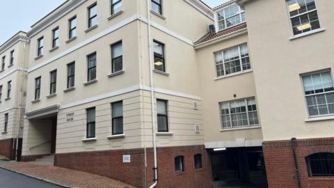 A yellow building with the words Utmost House on the side.