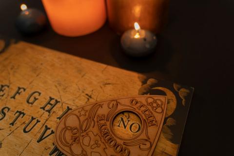 A ouija board, with a candle next to it