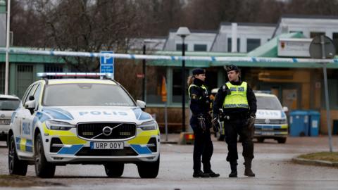 Swedish police officers stand near the Risbergska school, a day after a mass shooting there