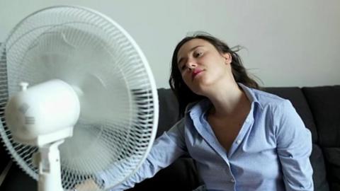 Woman uses electric fan