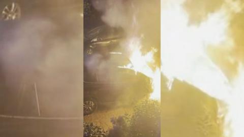 A car on fire on a street