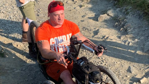 A man riding a hand-cranked mountain bike