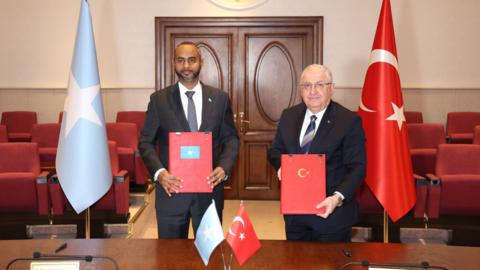 Somali and Turkish defence ministers pose in front of flags