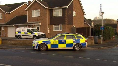 Police vehicles outside a house