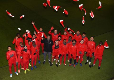 Liverpool manager Jurgen Klopp and his players throw Santa hats into the air during a Christmas day training session