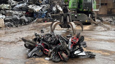 The picture shows e-scooters and motorcycles seized from people involved in anti-social behaviour or other crimes being crushed.
