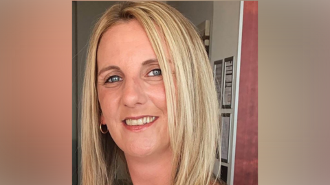 Carly Hicks has blonde hair and is smiling.