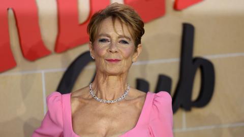 Celia Imrie in a pink dress at a film premiere. 