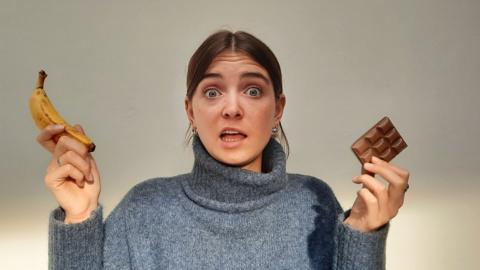 Author, Lottie Savage, holding a banana and pieces of chocolate