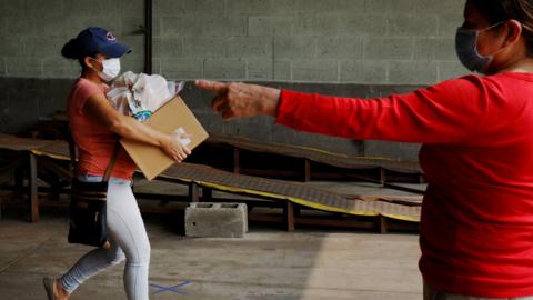 A resident picks up free groceries distributed by the Chelsea Collaborative"s food pantry, in Chelsea, a city hard hit by the coronavirus disease (COVID-19) outbreak, Massachusetts, U.S., September 15, 2020.