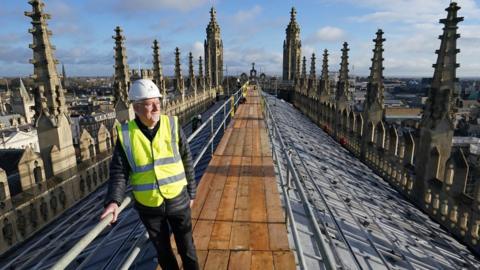 Stephen Cherry, Dean of King's College Chapel, views the installation of 438 new photovoltaic solar panels on the roof of the recently restored Chapel at King's College Cambridge.