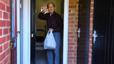 An elderly man receives urgent food supplies from Bucks Angels C-19 Community Group in High Wycombe, Buckinghamshire, Britain, 25 April, 2020.