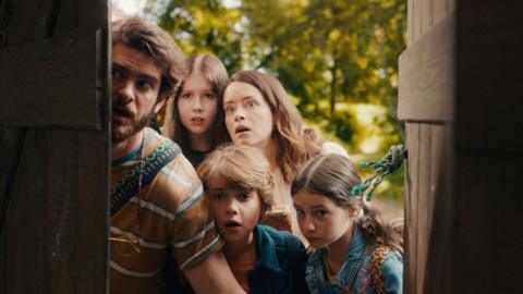 A family looks in awe through an open old door