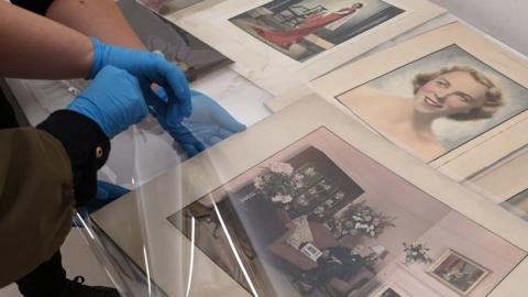 Taking a photographic print by E. Chambre Hardman out of its protective sleeve