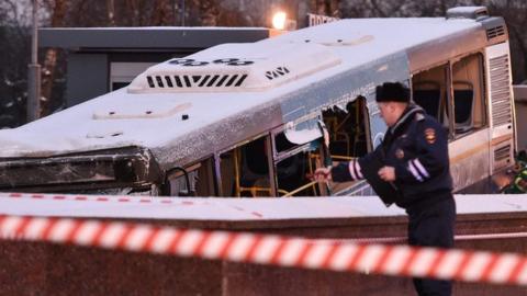 Rescuers pull out a city bus after it ploughed into a pedestrian underpass in western Moscow on December 25, 2017