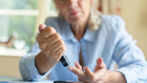 Woman taking blood for diabetes test