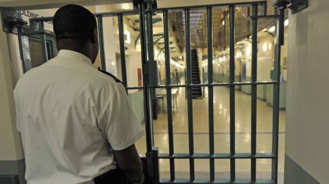 A prison officer locks a door at Wormwood Scrubs,