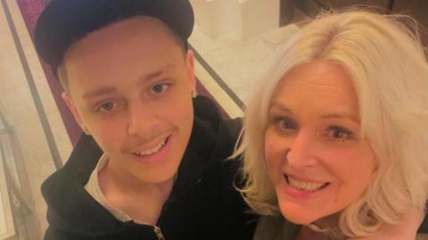 A selfie-style image of Billy and Abi Davies. They are smiling and looking into the camera. Billy is wearing a black hooded top and has his arm around Abi. 