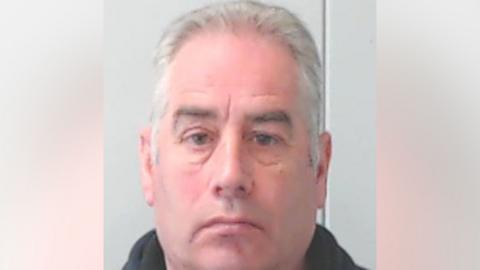 A police mugshot of convicted rapist Paul Patrick, a man in his early 60s with combed-back white hair