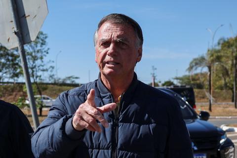 Brazil's former President Jair Bolsonaro gestures as he arrives to the State Secretariat of Penitentiary Administration headquarters in Brasilia, Brazil 