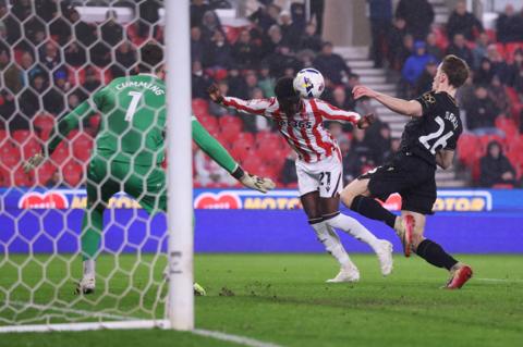 Jesurun Rak-Sakyi heads the ball across a defender and the goalkeeper