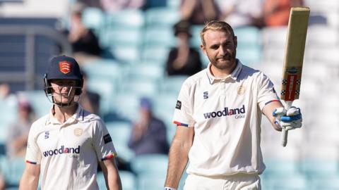 Paul Walter raises his bat after reaching three figures for Essex