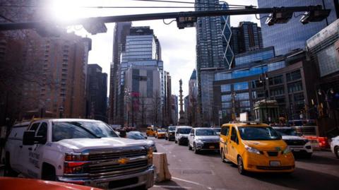 Cars drive under E-ZPass readers and license plate-scanning cameras on Columbus Circle as congestion pricing takes effect in New York City on January 5, 2025 