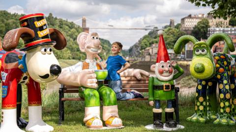 Freddie Hine-Haycock, 6, greets Wallace & Gromit sculptures unveiled as part of the Gromit Unleashed 2025 trail in Bristol.