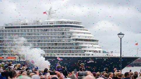 Members of the public attend the naming ceremony at Liverpool Pier Head for Cunard's Queen Anne with confetti being thrown and people flying Union Jack flags to celebrate.