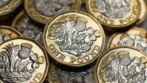 A close up of a group of £1 coins.