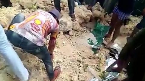 Men dig through earthquake rubble in the Philippines