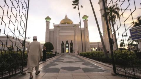 A Muslim man walks inside the Sultan Omar Ali Saifuddien mosque to perform the sunset prayer in Bandar Seri Begawan