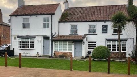 A  closed village pub in Murton, near York. The building has two storeys and is whitewashed