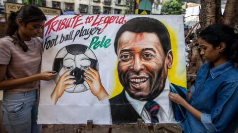 Two fans with a picture of Pele