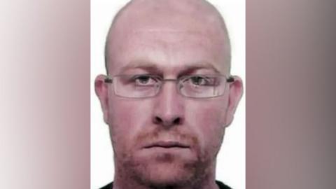 Police image of how fugitive Kevin Parle wearing glasses and with short red hair and stubble may look after years on the run