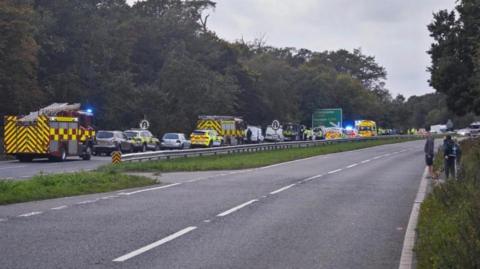 Traffic on the A27 near the scene of the collision with fire engines, police cars and ambulances also there