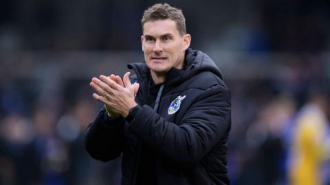 Matt Taylor applauds the fans while at Bristol Rovers in his club branded clothing