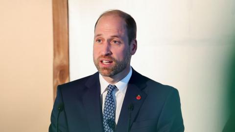 Prince William pictured speaking at a podium 