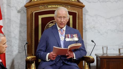 King Charles delivers a speech from the throne next to Canada's Prime Minister Mark Carney at the Senate Chamber in Ottawa, Ontario, Canada,