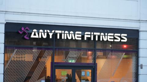 A glass front of a gym with a sign that reads Anytime Fitness 