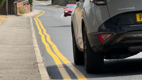 Wonky yellow lines on road.