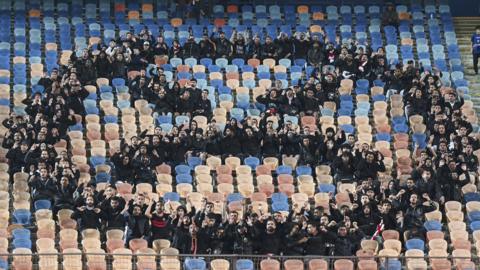 Zamalek fans in black form an angry face emoji in the stand