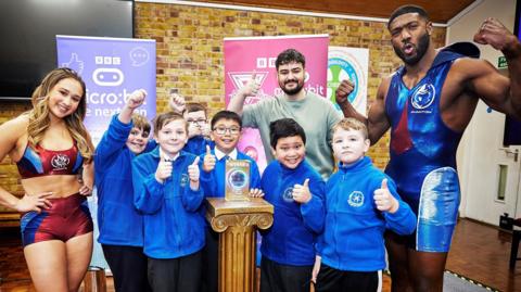 Gladiators Phantom and Dynamite with school children celebrating