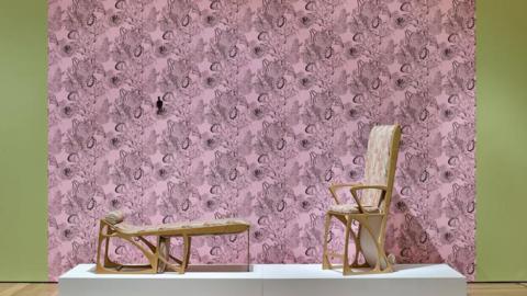 A work by Marc Camille Chaimowicz made up of a pink backdrop and some chairs.