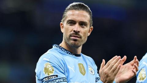 Jack Grealish applauds in Manchester City kit