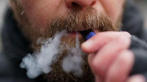 A man using a disposable vape