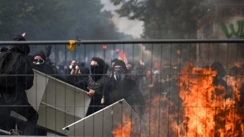 Protesters wear masks and light fire as thousands of people take to the streets during the May Day demonstrations on May 1, 2018 in Paris,